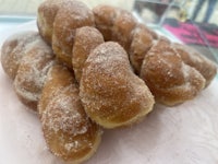 a plate of sugared doughnuts on a white plate